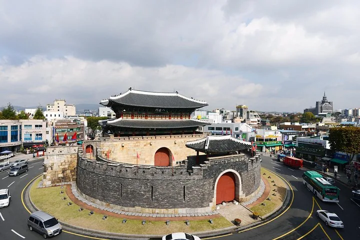 Una gran estructura tradicional de puerta coreana situada dentro de una rotonda de tráfico.