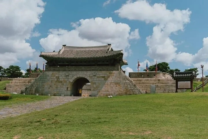 A wide stone fortress gate with an arched entrance under a blue sky.